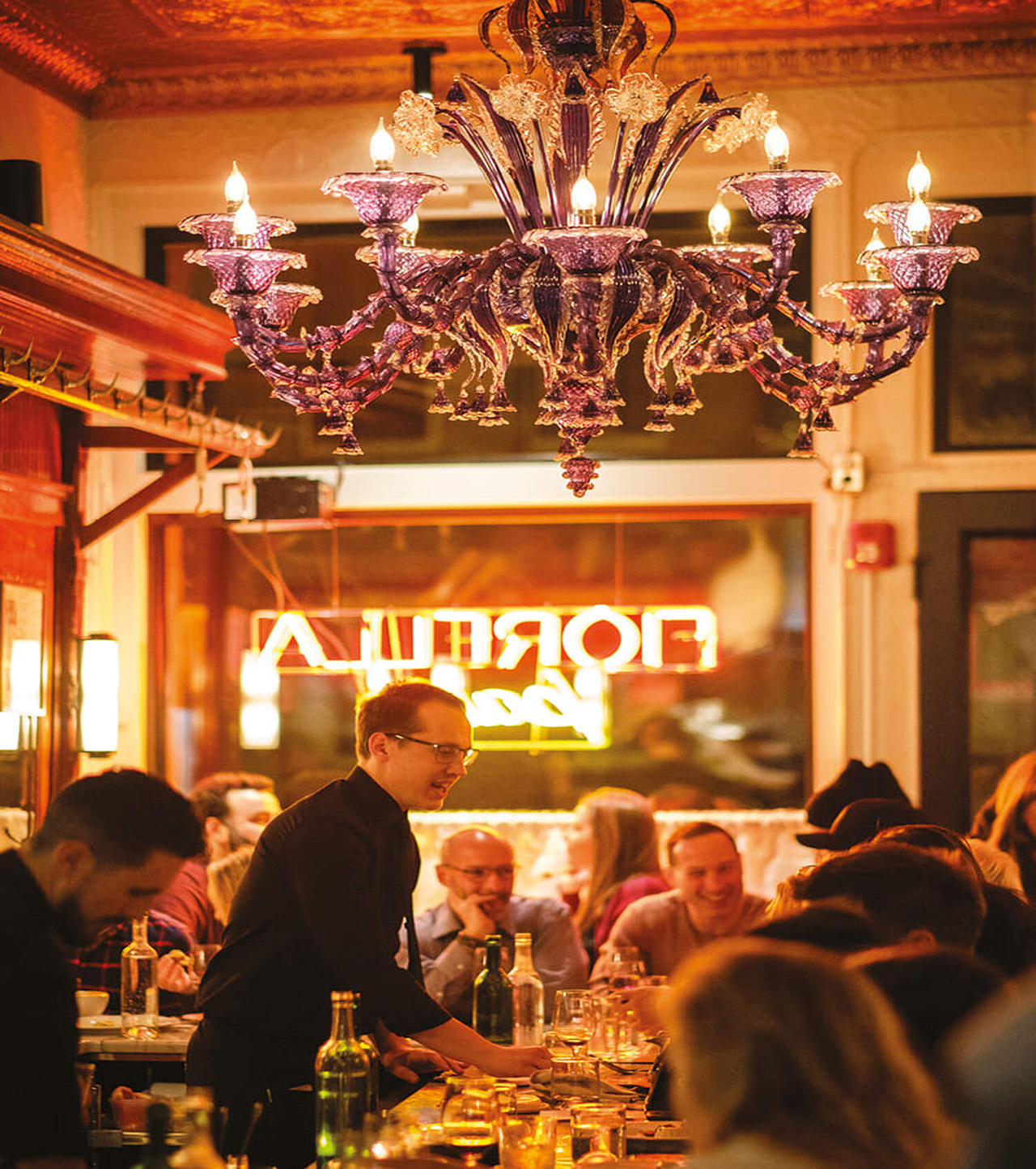 Barman serving customers in a busy bar.