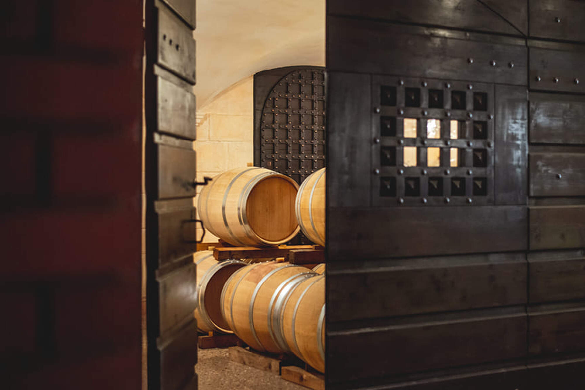Door opening to Allegrini wine cellar where wine barrels are visible.