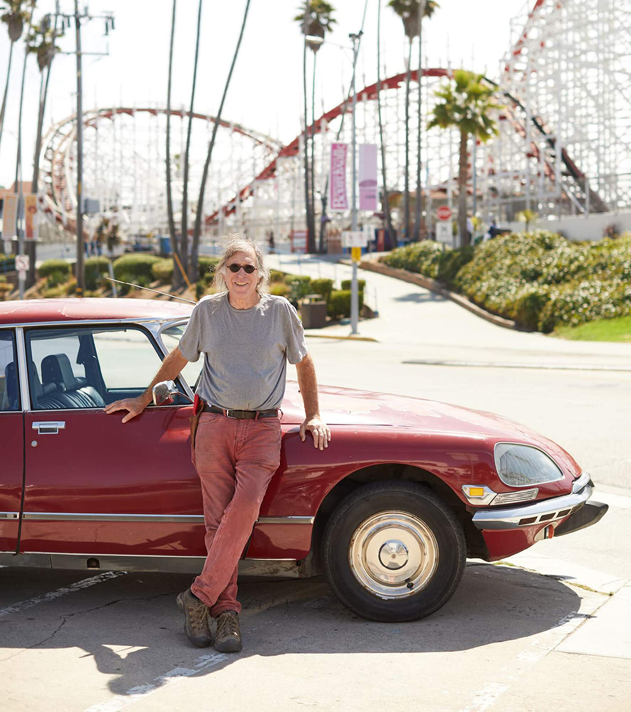 Winemaker for Language of Yes wines leaning on a classic car in front of a fairground.