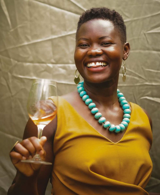 Maze Row Alice Achayo holding a glass of wine.