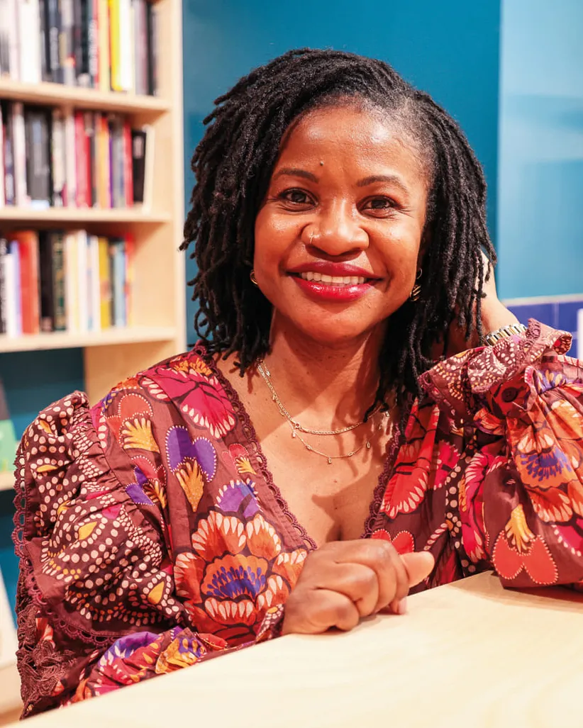 Portrait of a woman sitting at a desk wearing a floral shirt