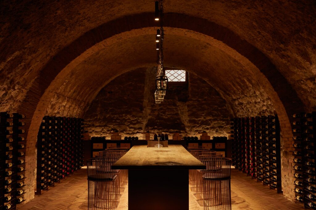 Candlelit tasting table in a vaulted wine cellar