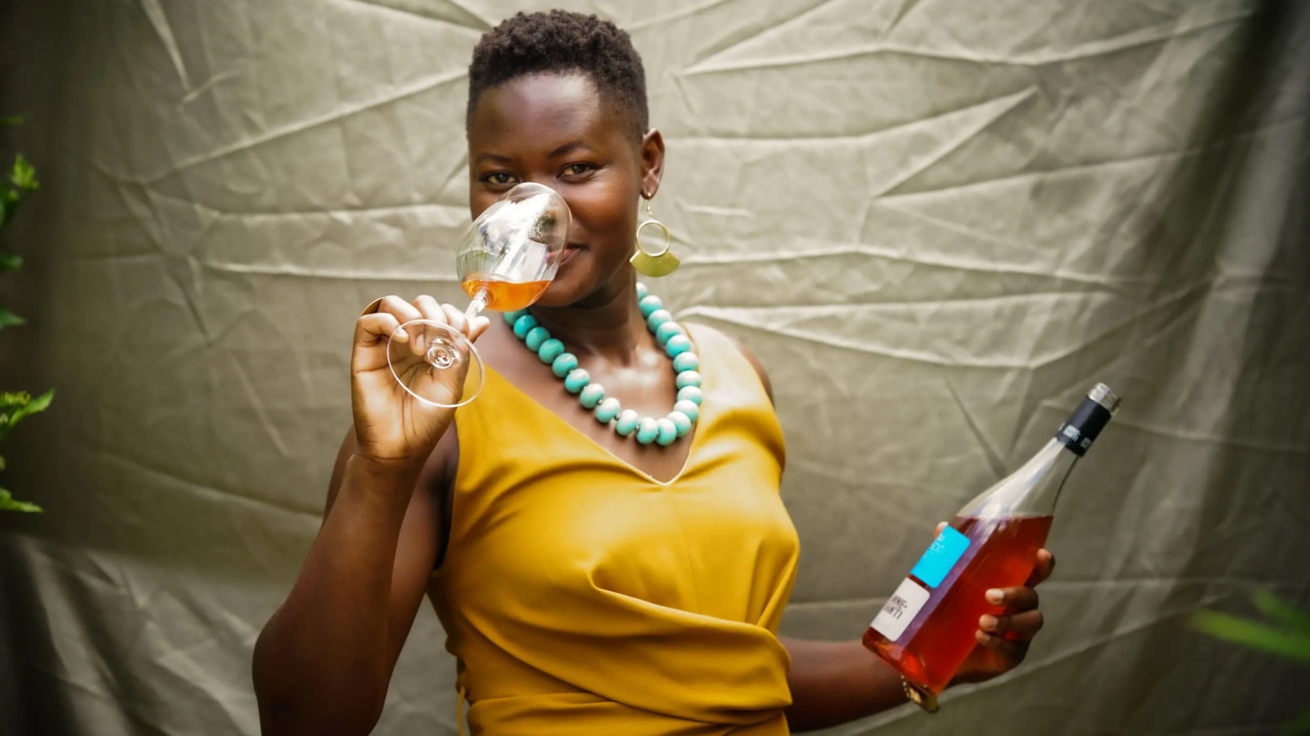 Alice Achayo with a bottle of wine