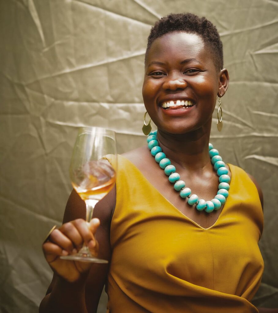 Alice Achayo with a bottle of wine