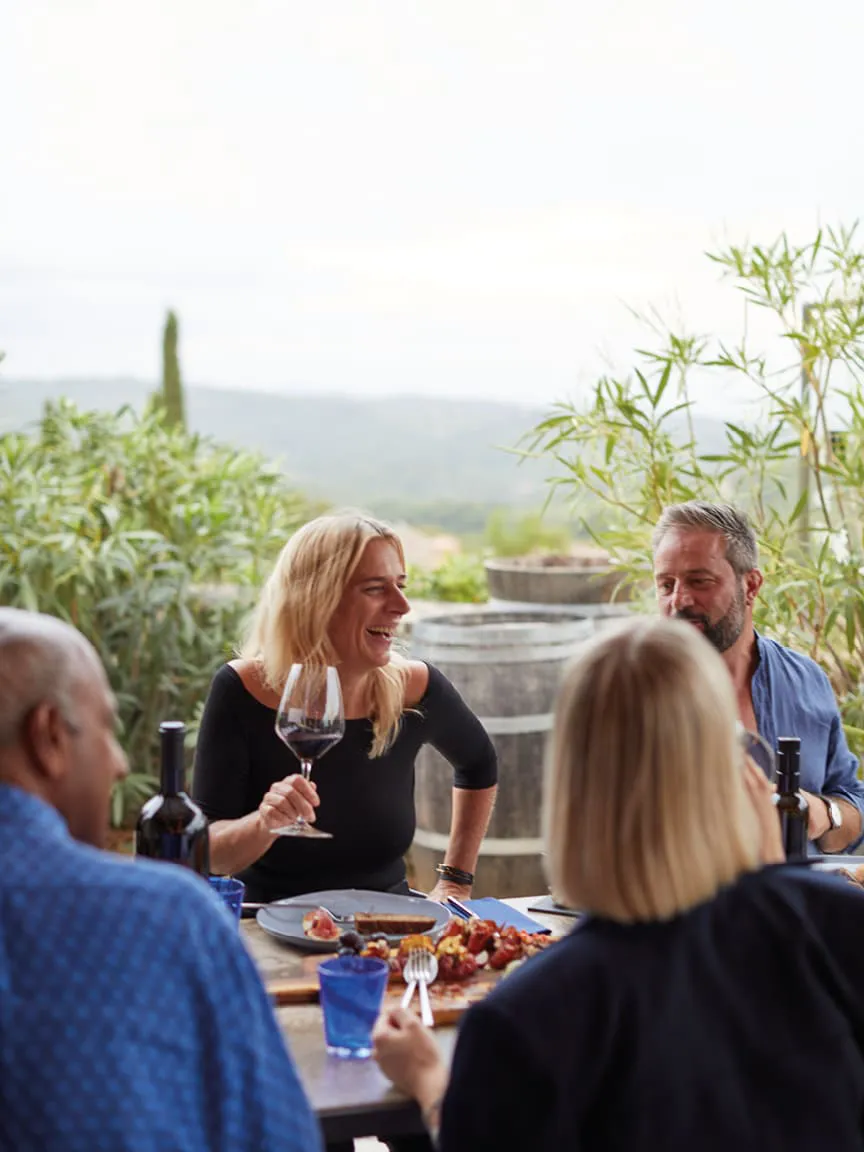People gathered around a table enjoying food and wine