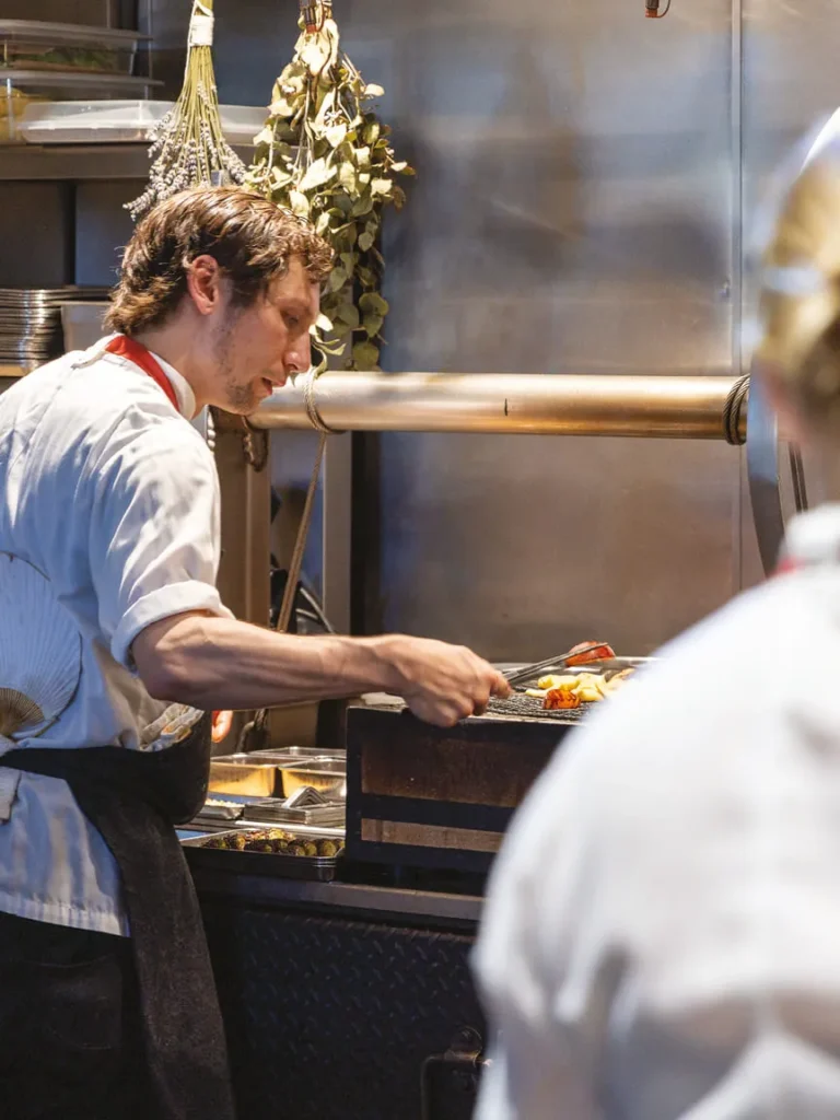Chef preparing food in a restaurant kitchen.