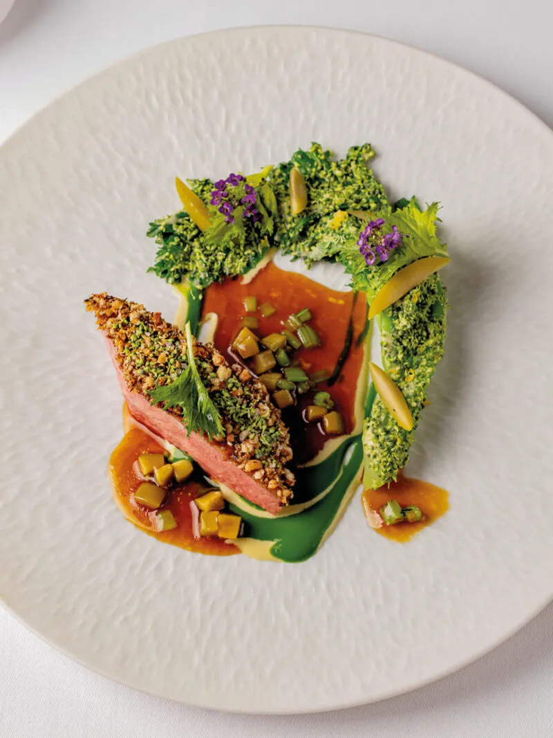A dish of duck from Sladesdown Farm in Devon, UK, with cime di rapa, Cerignola olives and cedrat; the wood-paneled dining room